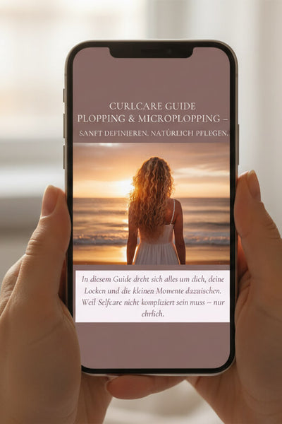 Eine Frau liest den Plopping und Selfcare Guide von Curly N Covered als Ebook auf ihrem Smartphone