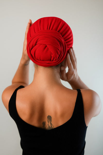 Rückansicht von einer hübschen Frau, die ein mohn rotes Bambus Haar Handtuch von Curly N Covered als Turban trägt