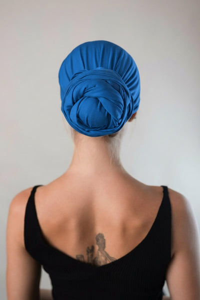 Rückansicht von einer hübschen Frau, die ein royalblaues Bambus Haar Handtuch von Curly N Covered als Turban trägt