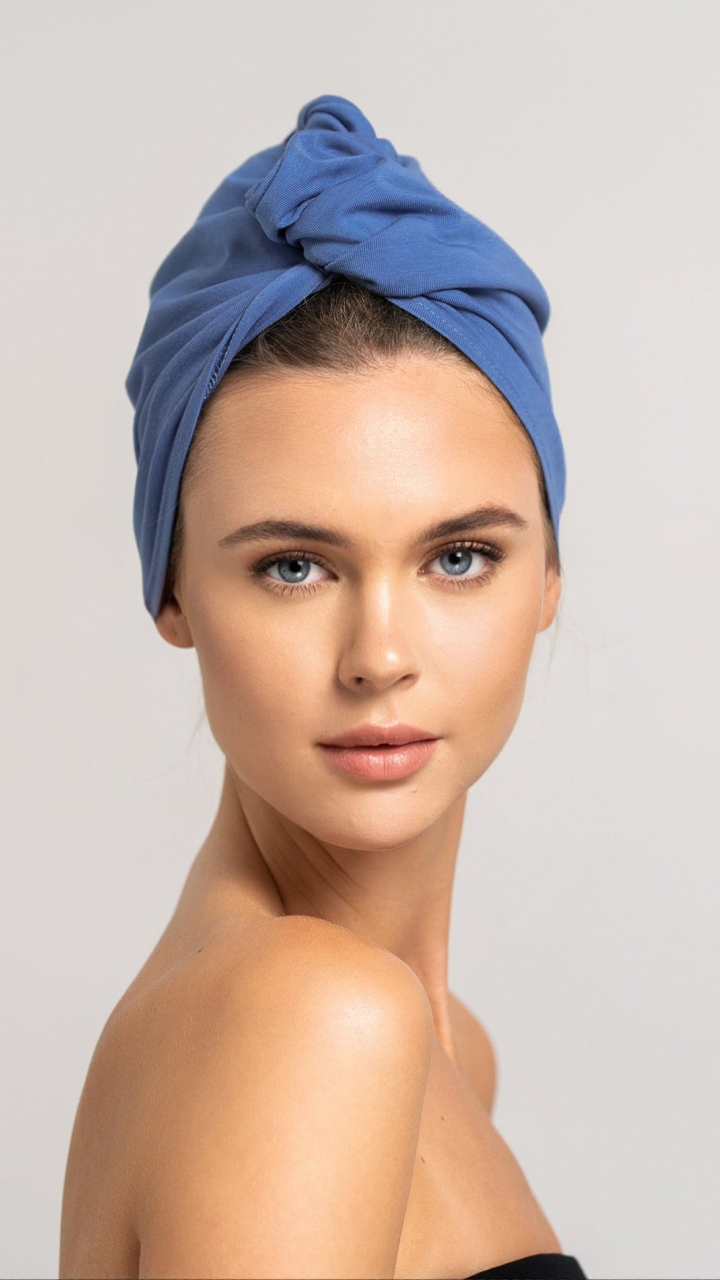 Bildhübsche Frau, die ein blaues Bambus Haar Handtuch von Curly'N'Covered als Turban trägt