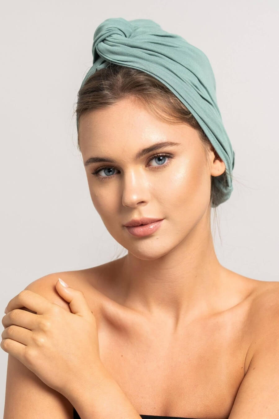 Schöne Frau mit blonden Haaren trägt ein mint grünes Bambus Haar Handtuch von Curly'N'Covered als Turban