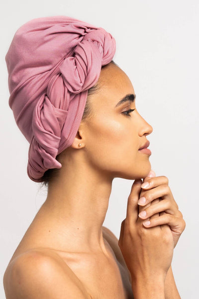 Bildhübsche Frau, die ein rosa Bambus Haar Handtuch von Curly'N'Covered als Turban trägt