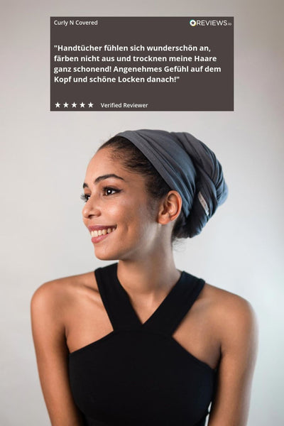 Wunderschöne Frau mit schwarzen Haaren trägt ein graues Bambus Handtuch von Curly N Covered um ihre Haare zu ploppen.