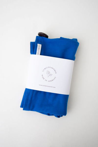 Bambus Turban Handtuch mit Kokosnussknopf in royal blau von Curly N Covered, mit Banderole umwickelt auf weißem Hintergrund