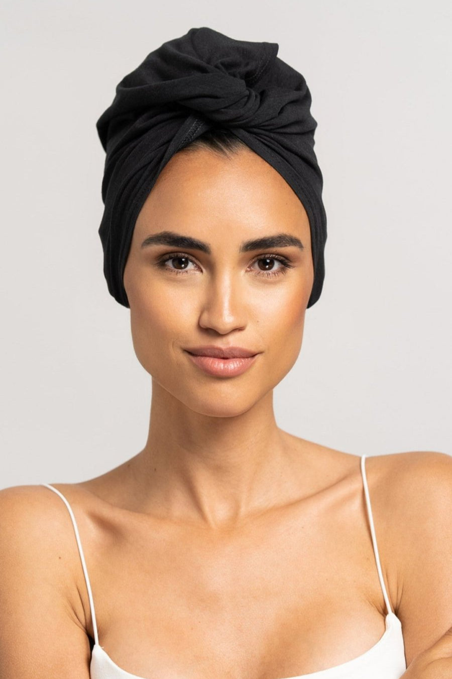 Bildschöne Frau trägt schwarzes Bambus Turban Handtuch von CURLY N COVERED als Turban gewickelt, perfekt für die Plopping Methode