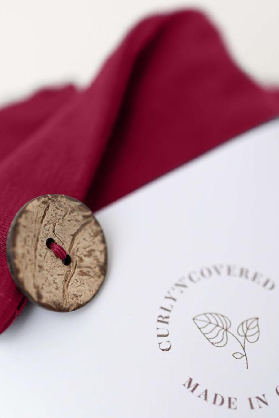 Detailaufnahme des Kokosnussknopfs des Bambus Turban Handtuchs in bordeaux von CURLY N COVERED
