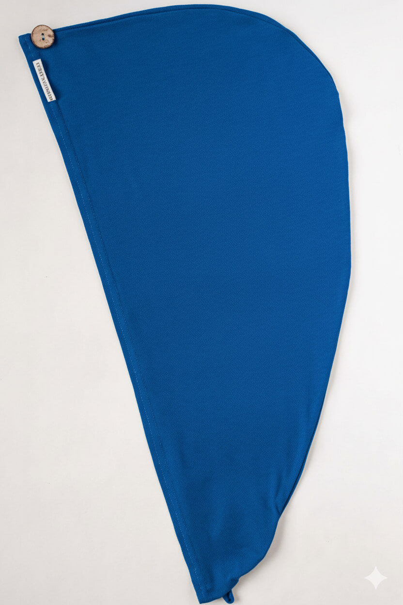 Bambus Turban Handtuch mit Kokosnussknopf in royal blau von Curly N Covered, ausgebreitet auf weißem Hintergrund