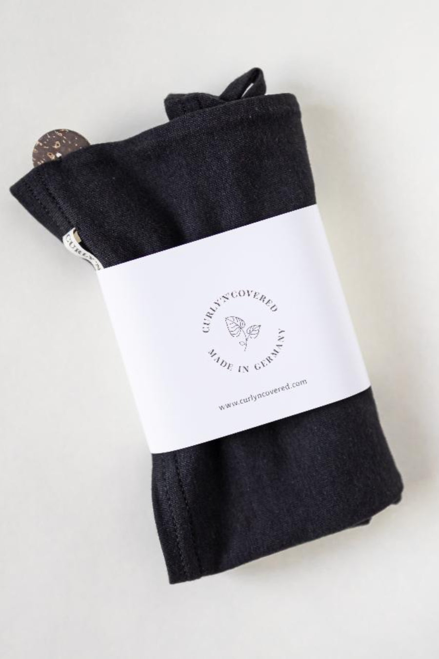 Bambus Turban Handtuch mit Kokosnussknopf in schwarz von CURLY N COVERED, mit Banderole umwickelt auf weißem Hintergrund
