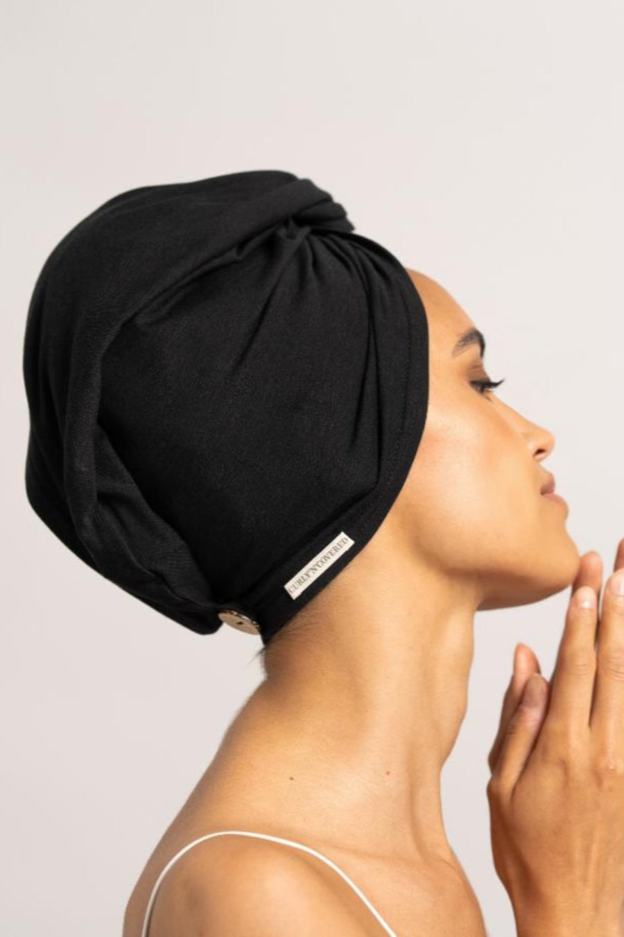 Bildschöne Frau im Seitenprofil trägt schwarzes Bambus Turban Handtuch von CURLY N COVERED als Turban gewickelt