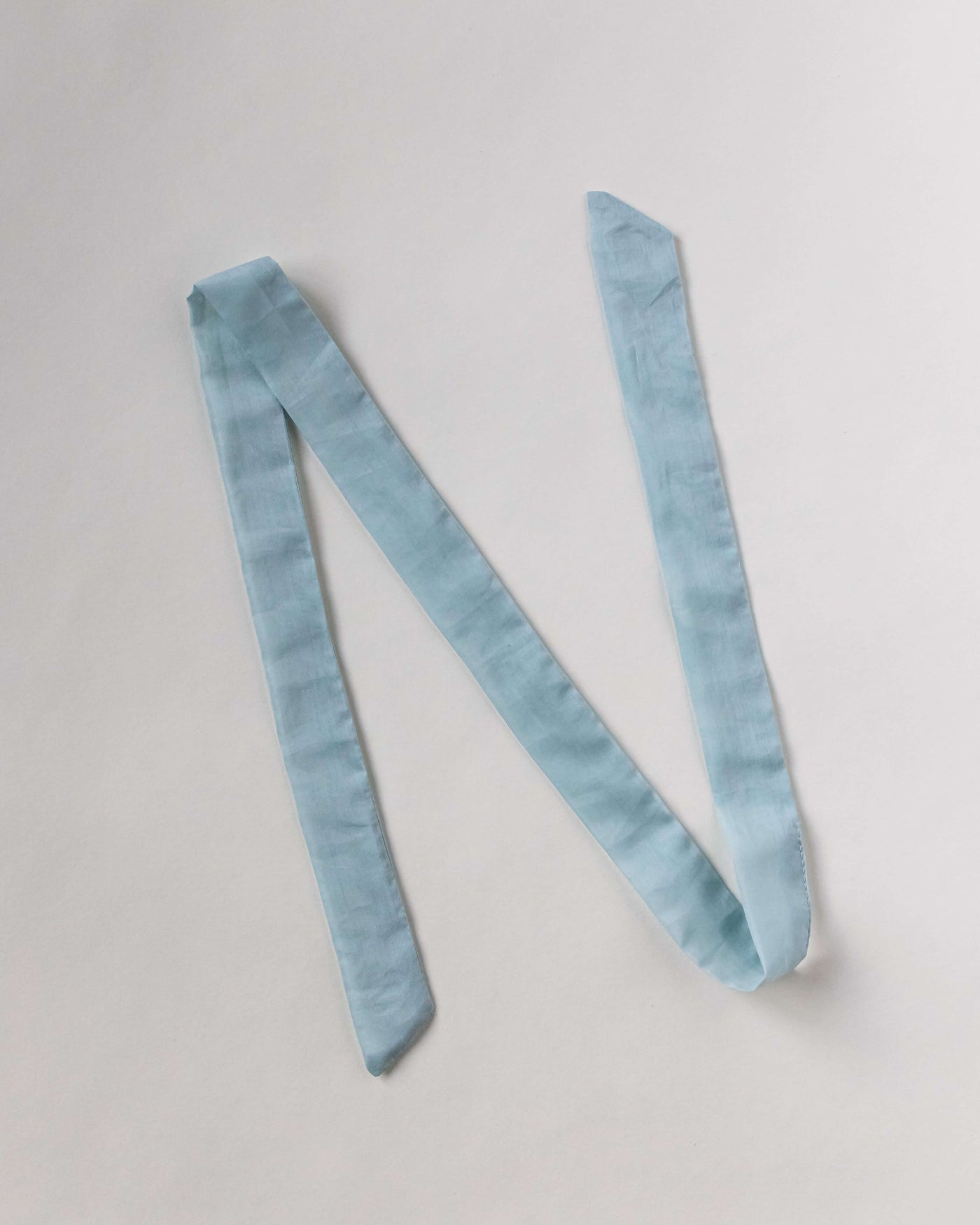 Haarband aus Baumwollseide in himmelblau von CURLY N COVERED vor weißem Hintergrund ausgelegt