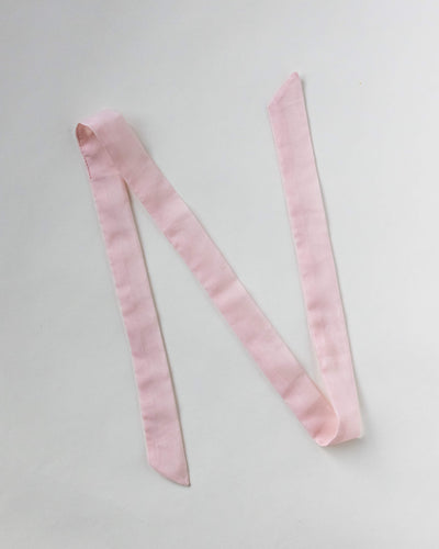 Haarband aus Baumwollseide in rosa von CURLY N COVERED vor weißem Hintergrund ausgelegt