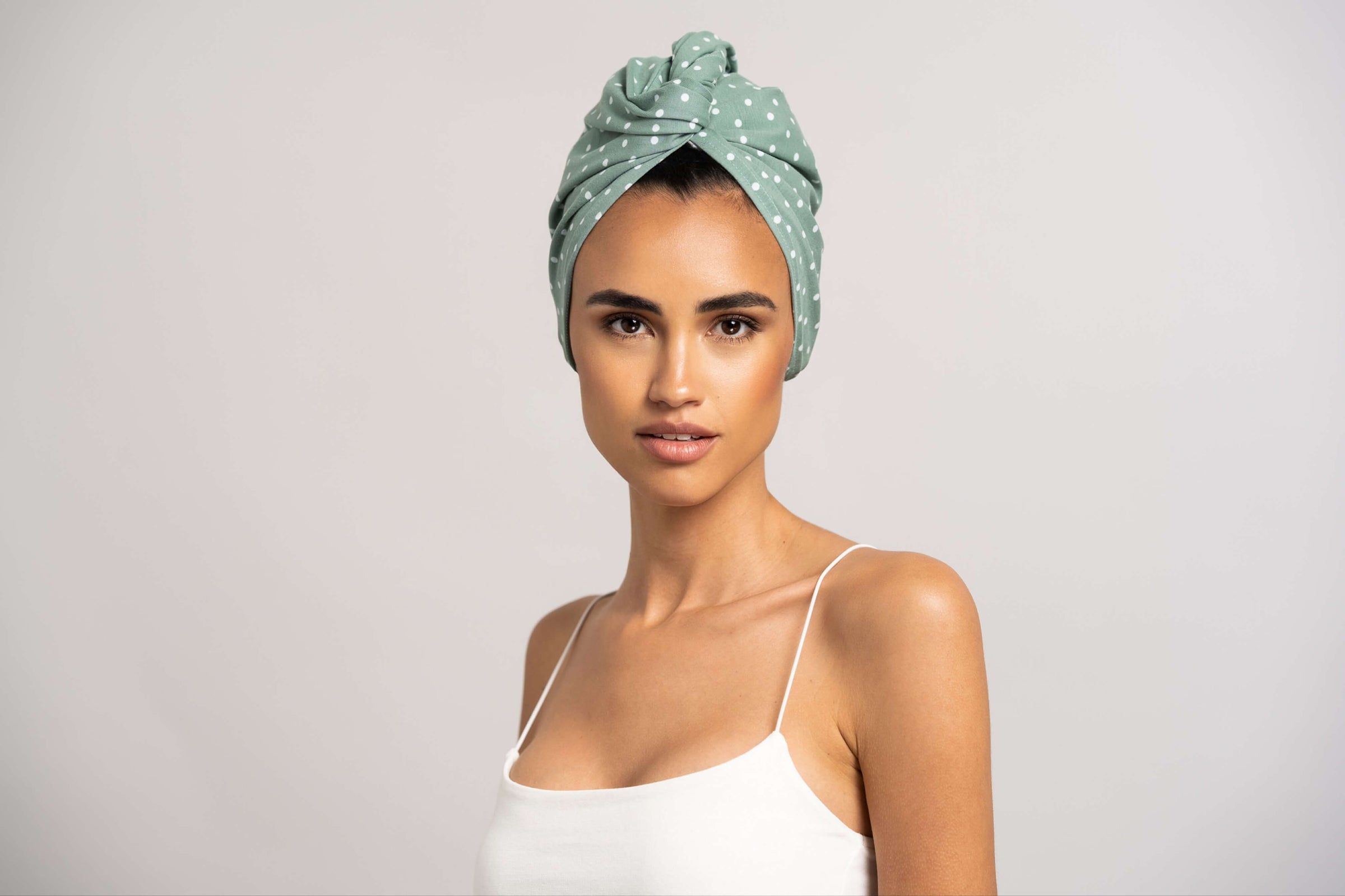 Bildhübsche Frau trägt grünen Turban mit weißen Punkten aus Baumwolle von Curly'N'Covered
