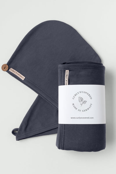 Ein Bundle aus Haarhandtuch und Turban Handtuch in Grau von CURLY N COVERED vor weißem Hintergrund