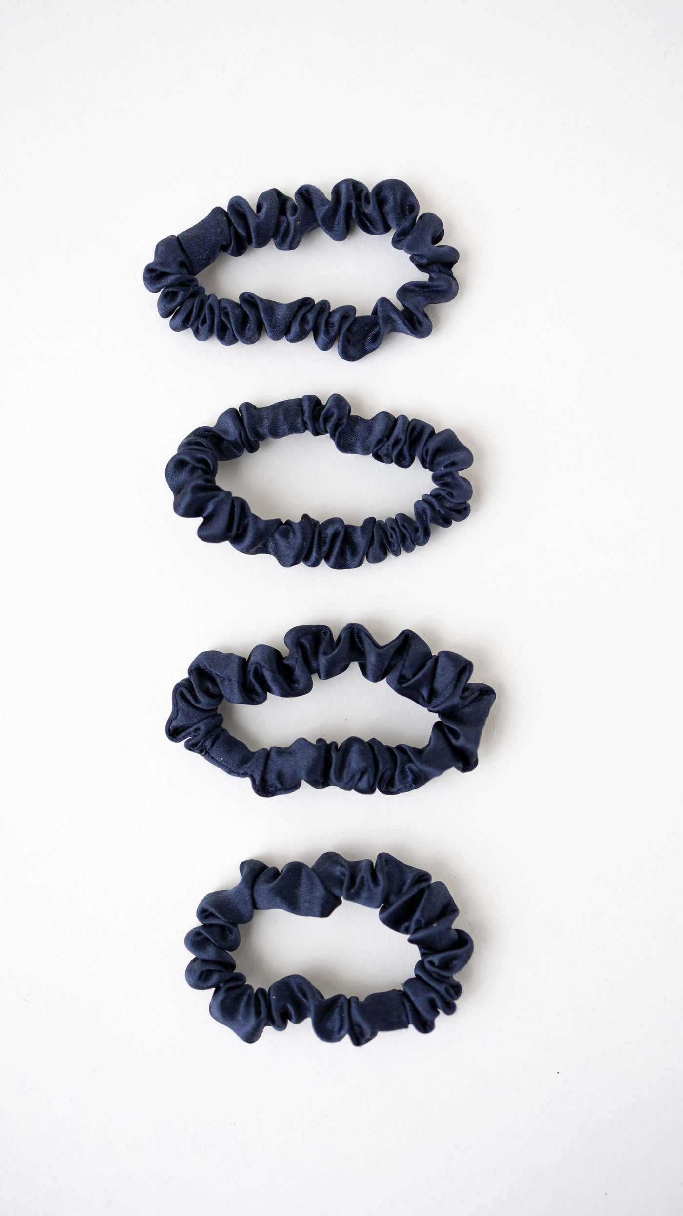 4er Bundle Mini Scrunchies von CURLY N COVERED aus reiner Seide in Marineblau auf weißem Hintergrund