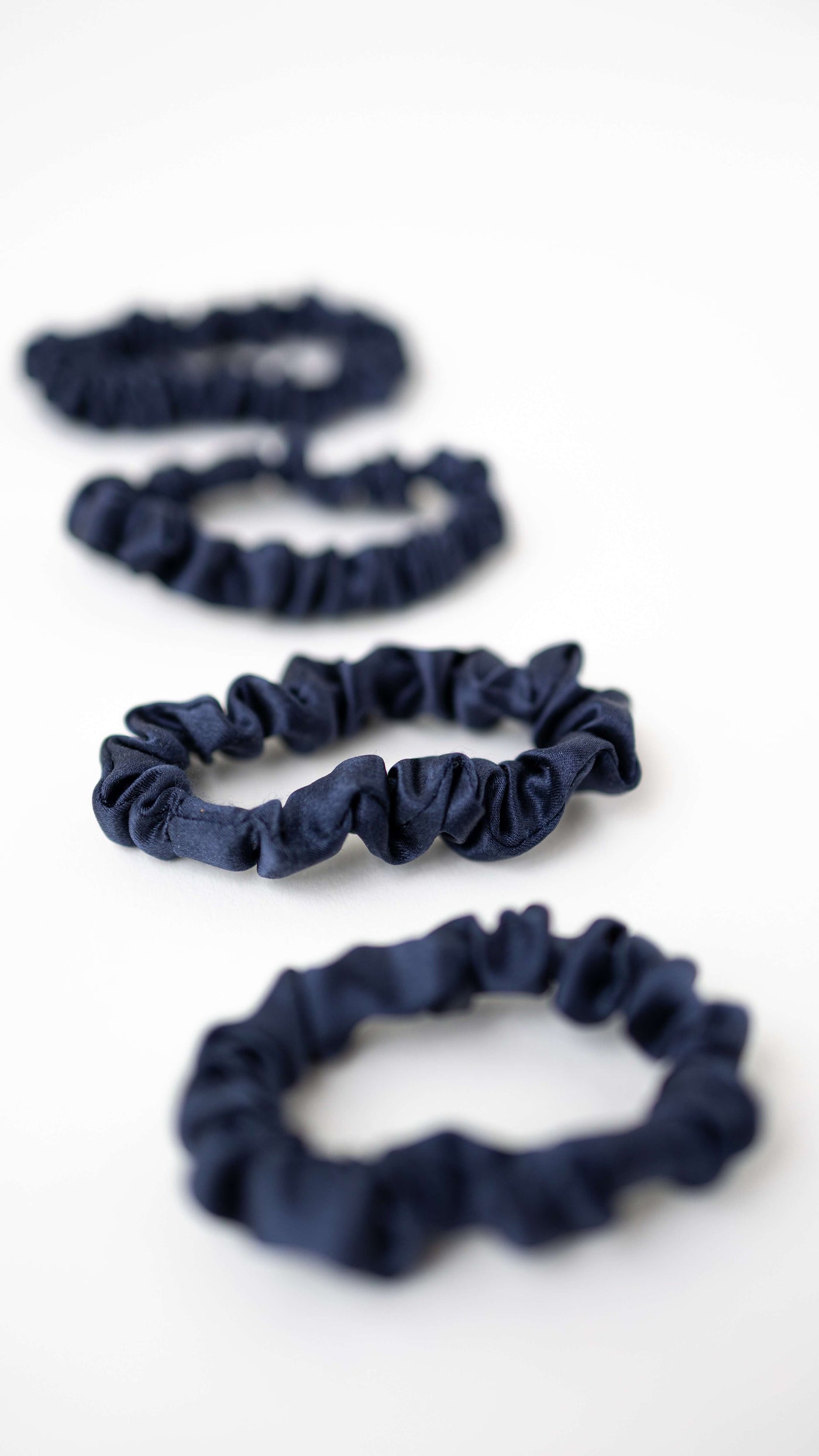 4er Bundle Mini Scrunchies von CURLY N COVERED aus 100% Seide in Marineblau auf weißem Hintergrund