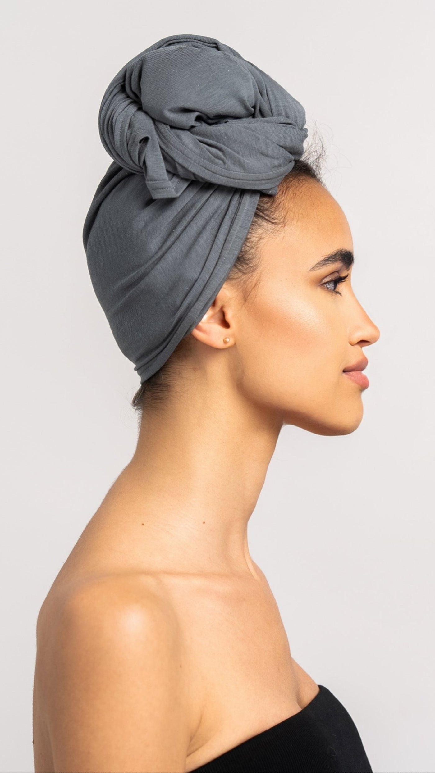 Seitenansicht von einer hübschen Frau, die ein graues Bambus Haar Handtuch von Curly'N'Covered als Turban trägt
