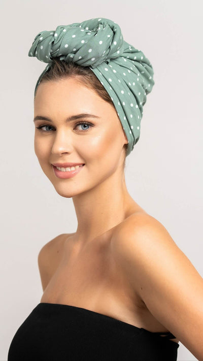 Wunderschöne Frau trägt ein grünes Haar Handtuch mit weißen Punkten aus Baumwolle von Curly'N'Covered als Turban gebunden