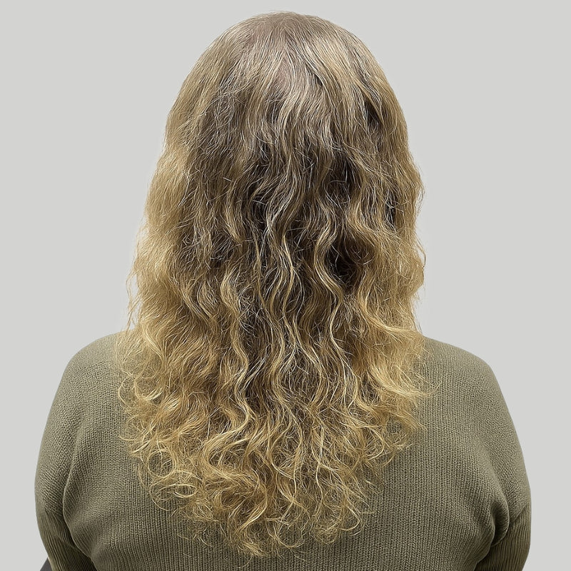 Hinterkopf einer blonden Frau mit Locken, die durch das Schlafen auf Baumwolle frizzig und stumpf sind.