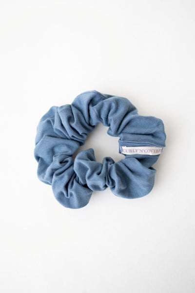 Ein Scrunchie aus weichem Bambus Stoff in Blau von Curly N Covered vor weißem Hintergrund