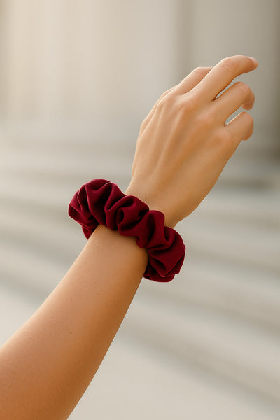 Ein bordeaux farbener Scrunchie aus Bambus-Stoff von Curly N Covered als Accessoire am Handgelenk