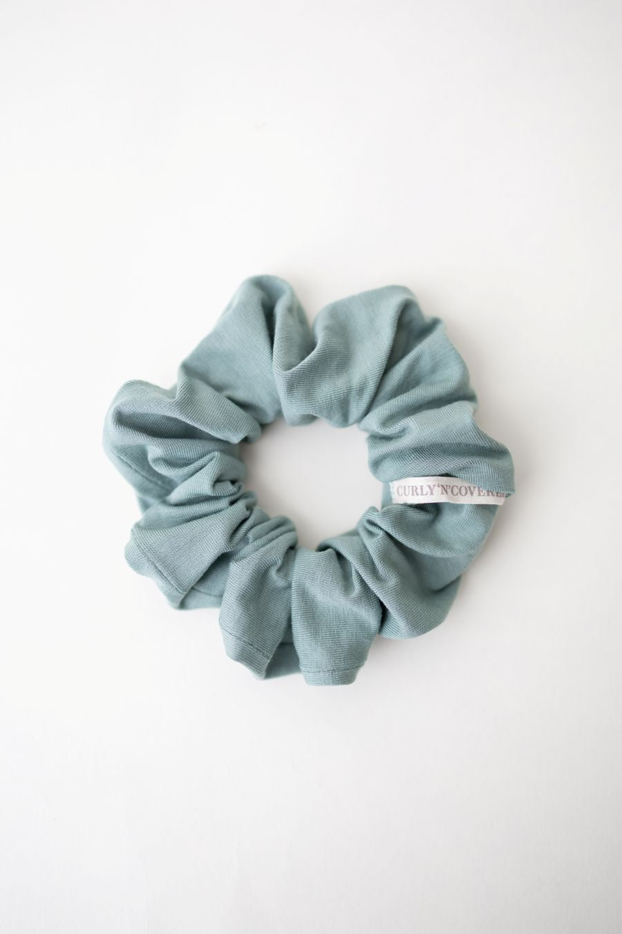 Ein Mint grüner Scrunchie aus weichem Bambus Stoff von Curly N Covered vor weißem Hintergrund