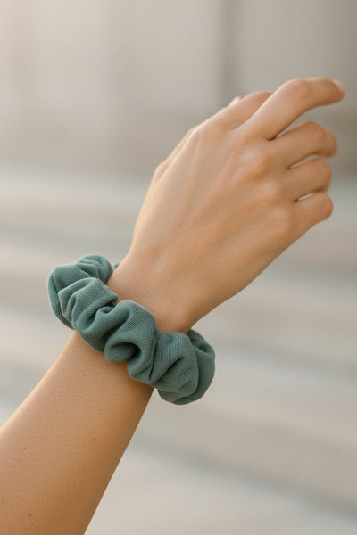 Ein mintgrüner Scrunchie aus Bambus-Stoff von Curly N Covered als Accessoire am Handgelenk