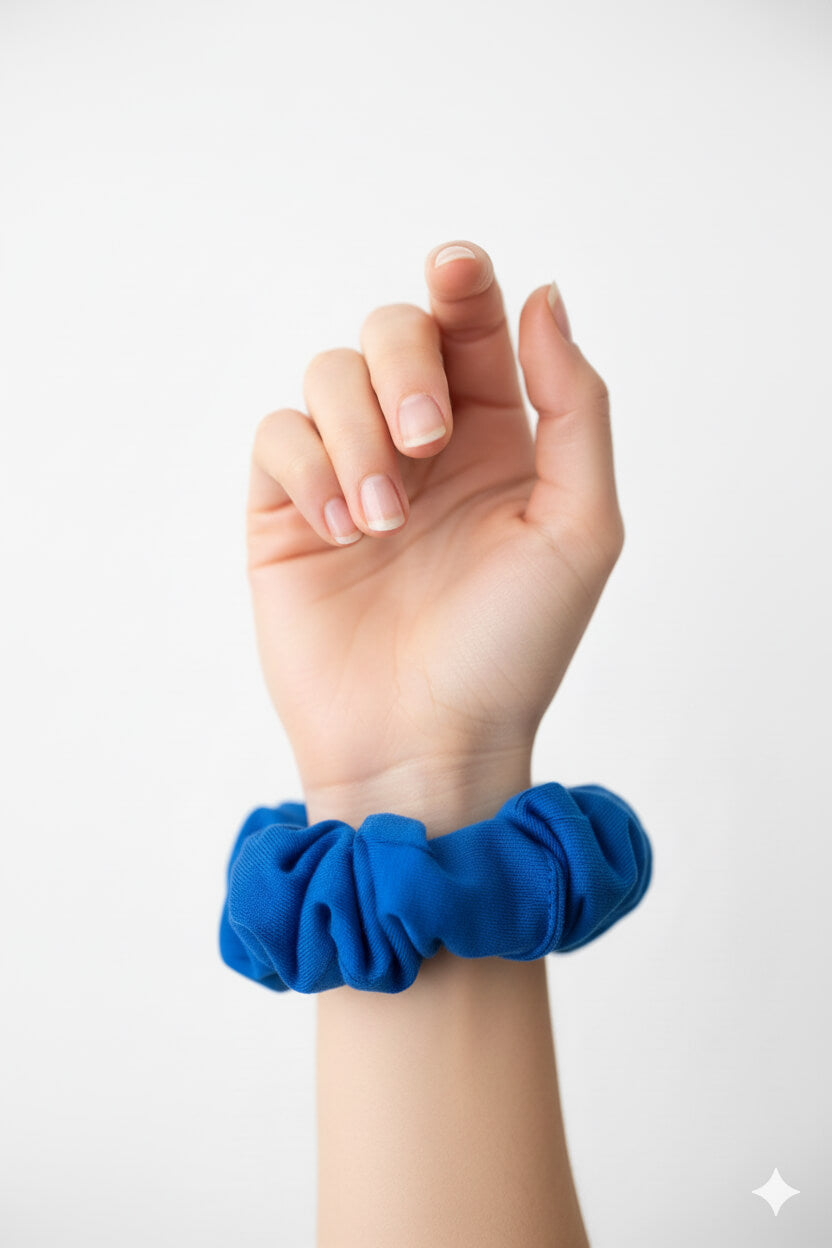 Ein royalblauer Scrunchie aus Bambus-Stoff von Curly N Covered als Accessoire am Handgelenk
