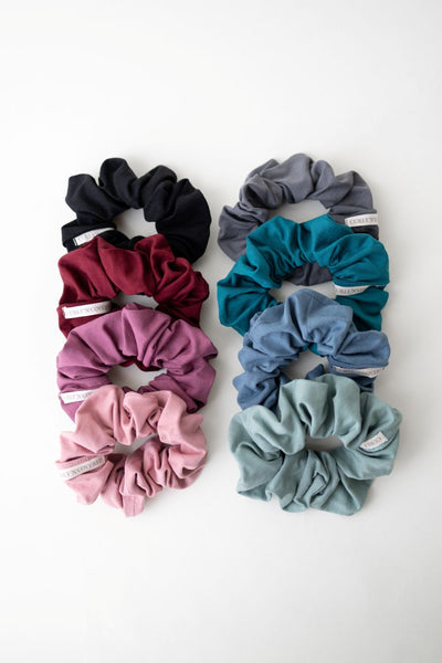 Scrunchies aus Bambus-Stoff von Curly N Covered in schwarz, bordeaux, rot, rosa, stahlblau, petrol, grau und mintgrün vor weißem Hintergrund
