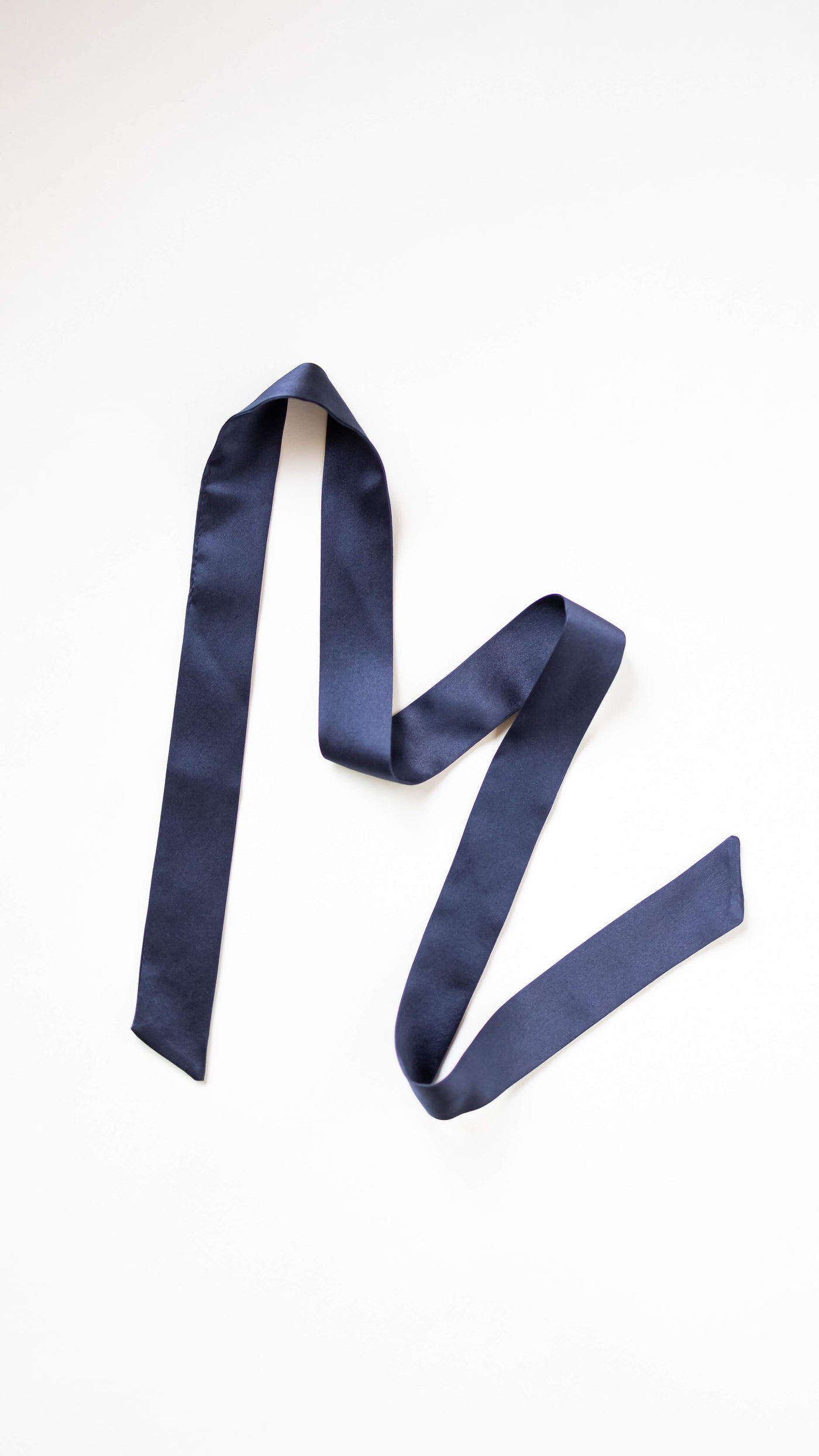 Marineblaues Haarband aus reiner Seide von CURLY N COVERED, ausgelegt vor weißem Hintergrund.