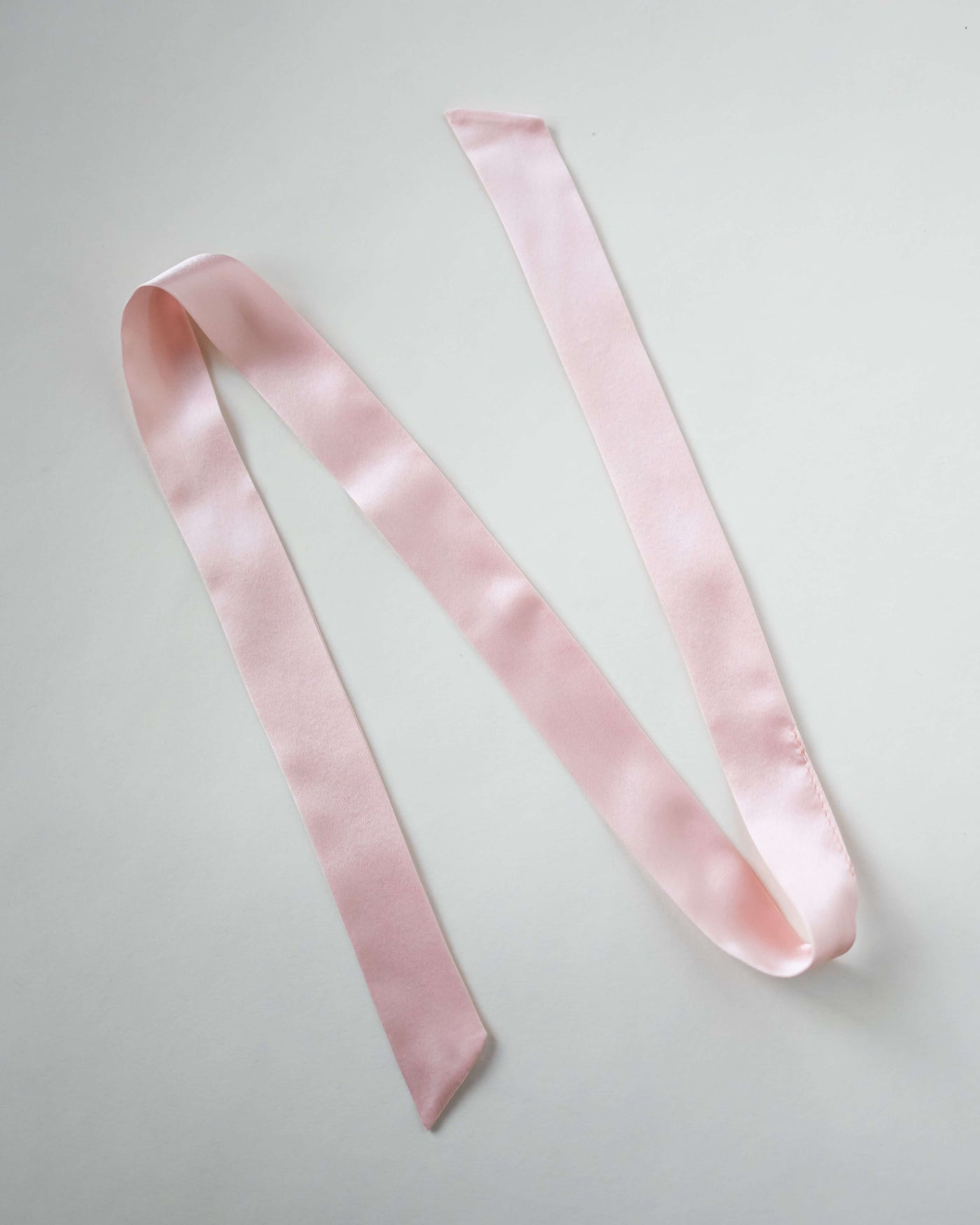 Haarband aus reiner Seide in rosa von Curly'N'Covered vor weißem Hintergrund ausgelegt