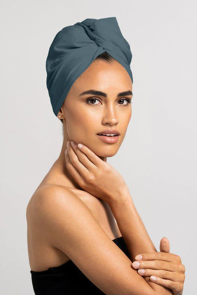 Wunderschöne Frau trägt stahlblaues Bambus Turban Handtuch von CURLY N COVERED als Turban gewickelt, perfekt für die Plopping Methode