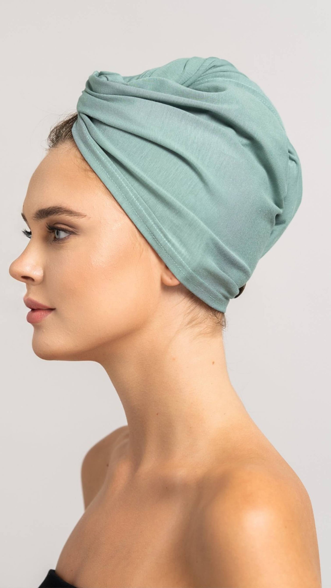 Seitenprofil einer wunderschönen Frau, die ein mint grünes Bambus Turban Handtuch von Curly'N'Covered als Turban gewickelt trägt