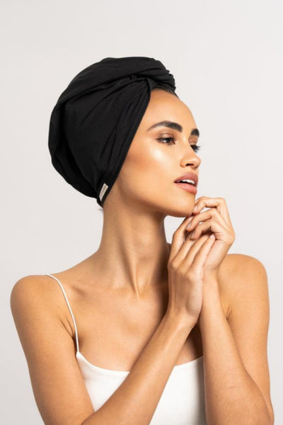 Bildschöne Frau trägt schwarzes Bambus Turban Handtuch von CURLY N COVERED als Turban gewickelt