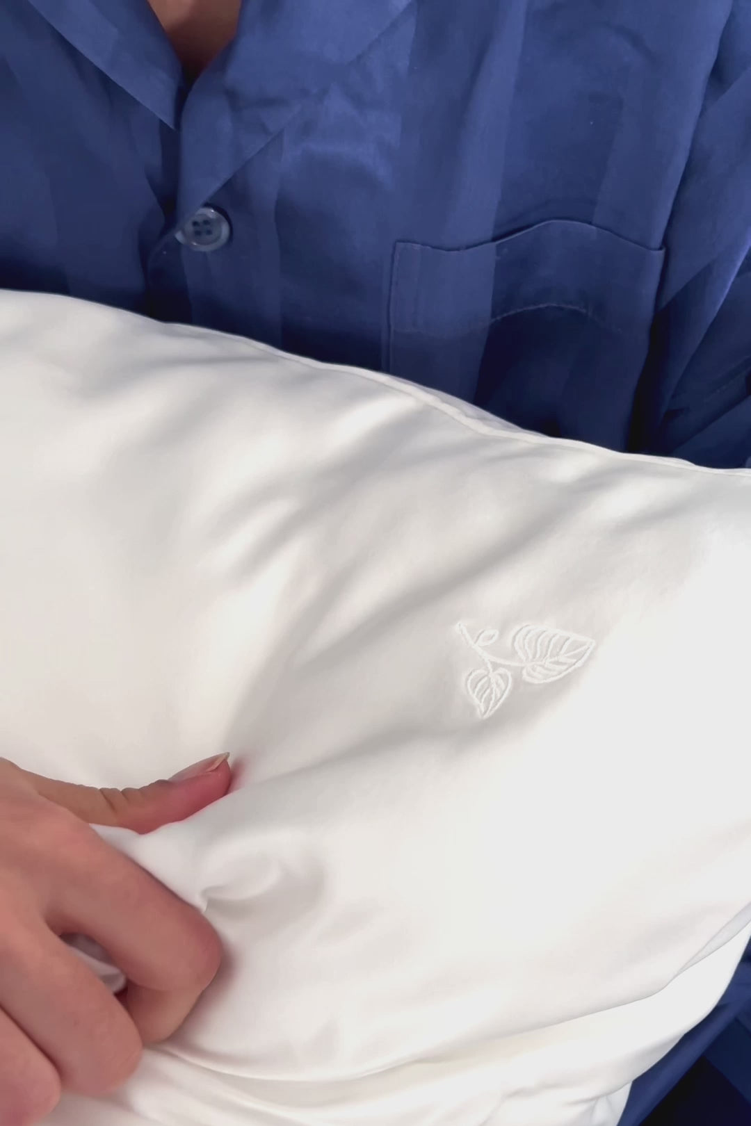 Schöne Frau umarmt einen Seidenkissenbezug aus reiner Maulbeerseide in cremeweiß von Curly N Covered